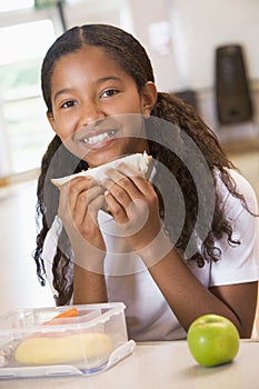 Schoolgirl enjoying her lunch in school cafeteria