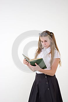 Schoolgirl with glasses surprised, reading book