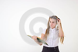 Schoolgirl with glasses surprised, reading book