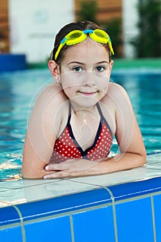 Schoolgirl with goggles in swimming pool