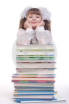 Schoolgirl leaning on a pile of books