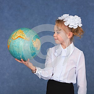 Schoolgirl looking at a geographical globe photo