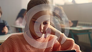 Schoolgirl looking on screen of digital tablet. Student studying with pad