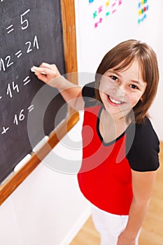 Schoolgirl looking up in front of chalkboard