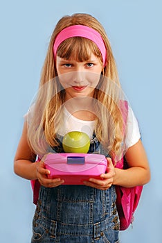 Schoolgirl with lunch box and apple