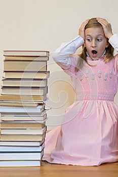 Schoolgirl is mad at books. The concept of hate to study and books. Unwillingness of a child to learn. Shock from the books. Shock