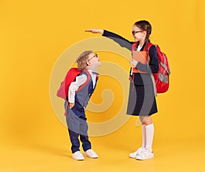 Schoolgirl measuring height of little brother