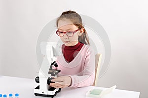 Schoolgirl with modern microscope
