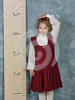 Schoolgirl next to the measuring ruler,