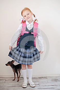 Schoolgirl with a pink briefcase and dog indoors