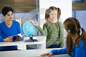 Schoolgirl pointing at globe