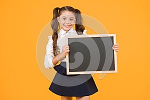 Schoolgirl pupil informing you. School girl hold blank chalkboard copy space. Announcement and promotion. Check this out photo