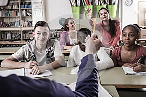 Schoolgirl raising her hand to answer a lesson