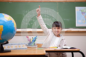 Schoolgirl raising her hand to answer a question