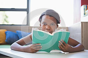 Schoolgirl reading book in library