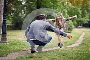 Schoolgirl running to dad to give him a hug photo