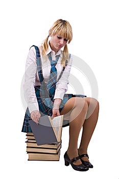 Schoolgirl sitting on books and watch furtively