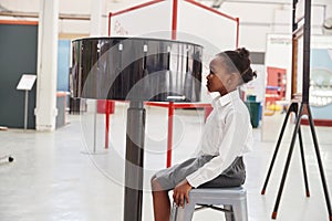 Schoolgirl sitting in front of zoetrope at a science centre