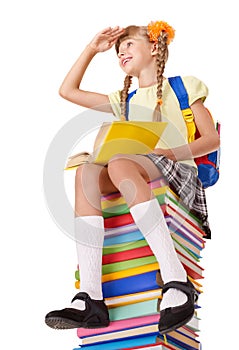 Schoolgirl sitting on pile of books.