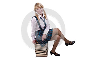 Schoolgirl is sitting on the stack of book.