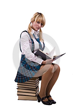 Schoolgirl sitting on the stack book and reading