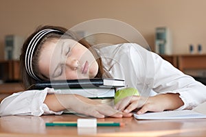 Schoolgirl is sleeping with her books at lesson