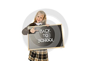 Schoolgirl smiling happy holding and showing small blackboard with text back to school