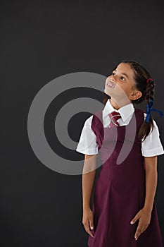 Schoolgirl standing against blackboard in classroom