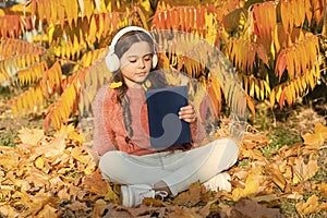 Schoolgirl study. Child enjoy reading. Visual and audio information. Little child enjoy learning at backyard. Kid study