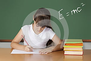 Schoolgirl studying at the classroom