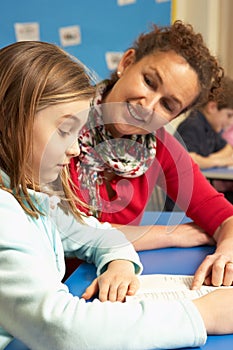 Schoolgirl Studying In Classroom With Teacher