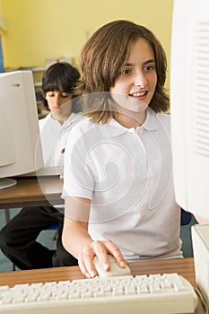 Schoolgirl studying in front of a school computer photo