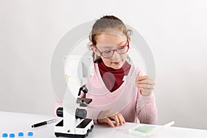 Schoolgirl with modern microscope