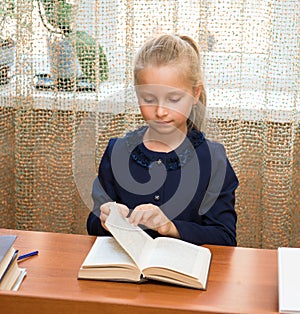 Schoolgirl studying and reading book at school