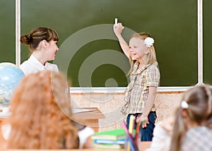 Schoolgirl and teacher near a school board