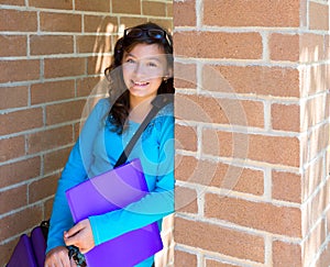 Schoolgirl teenager at school brick wall happy