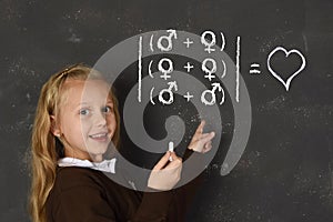 Schoolgirl in uniform holding chalk writing on blackboard standing for freedom of sexuality orientation photo