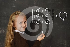 Schoolgirl in uniform holding chalk writing on blackboard standing for freedom of sexuality orientation photo