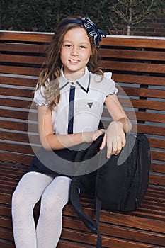 Schoolgirl in uniform waiting for the bus to school photo