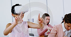 Schoolgirl using virtual reality headset in classroom