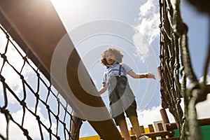 Schoolgirl walking on net bridge in the school playground