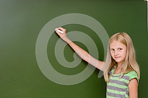 Schoolgirl wants to write something on the blackboard