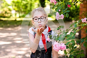 A schoolgirl in a white blouse with a red tie, with a bow in the class. Back to school concept
