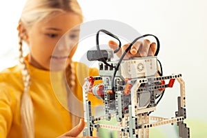 Schoolgirl working with a robot model at the lesson.