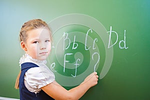 Schoolgirl wrote in chalk on blackboard and teach English language