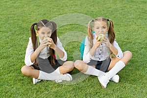 Schoolgirls eating apples relaxing schoolyard, healthy lunch concept