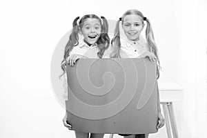 Schoolgirls hold advertisement poster copy space. Children hold advertising banner. Happy pupils children with blank