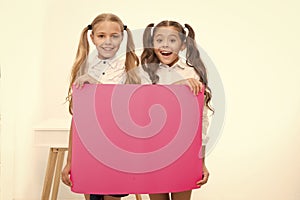 Schoolgirls hold advertisement poster copy space. Children hold advertising banner. Happy pupils children with blank