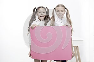 Schoolgirls hold advertisement poster copy space. Children hold advertising banner. Happy pupils children with blank