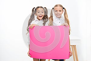 Schoolgirls hold advertisement poster copy space. Children hold advertising banner. Happy pupils children with blank